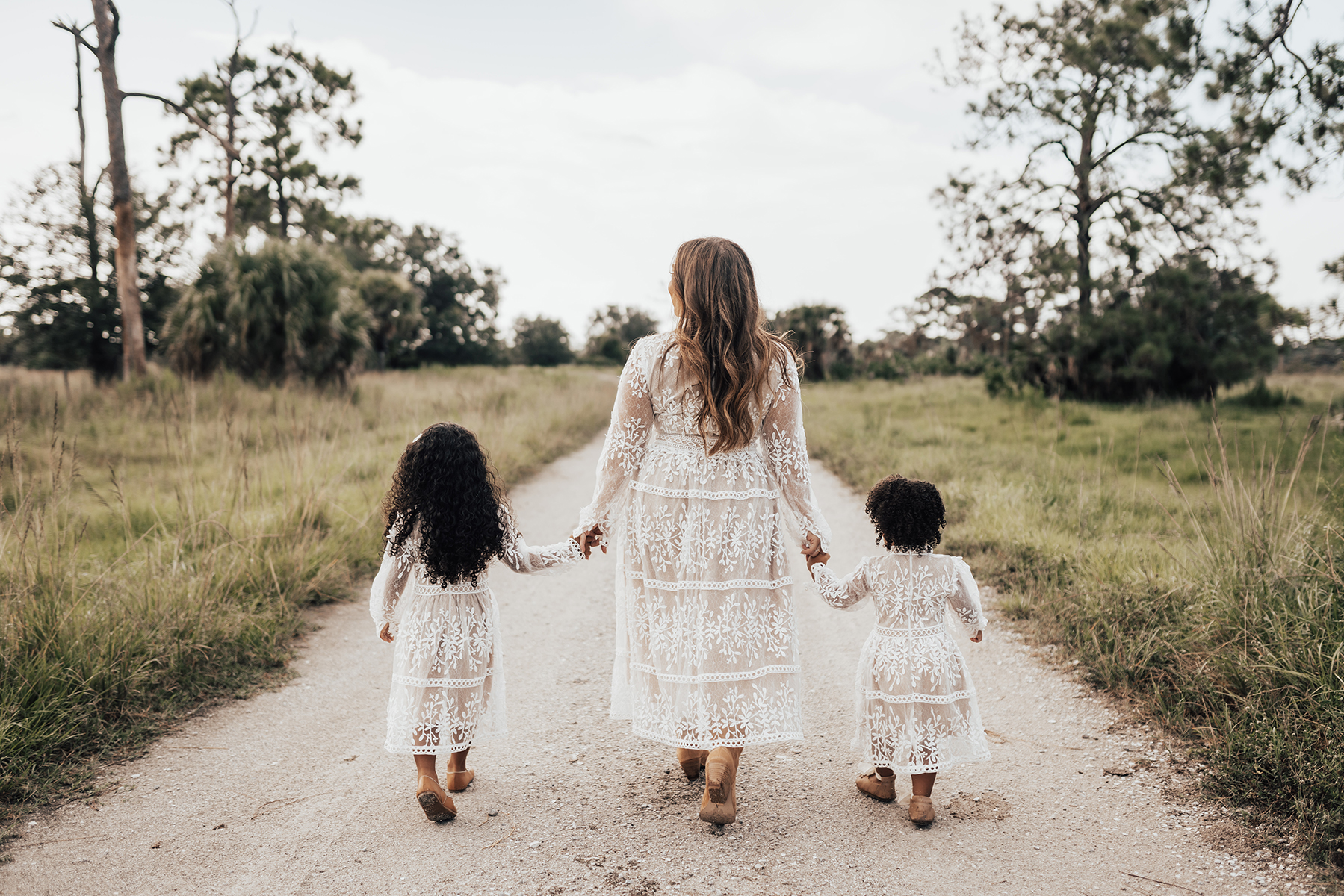 Dana Harvey's wife holding two children hands