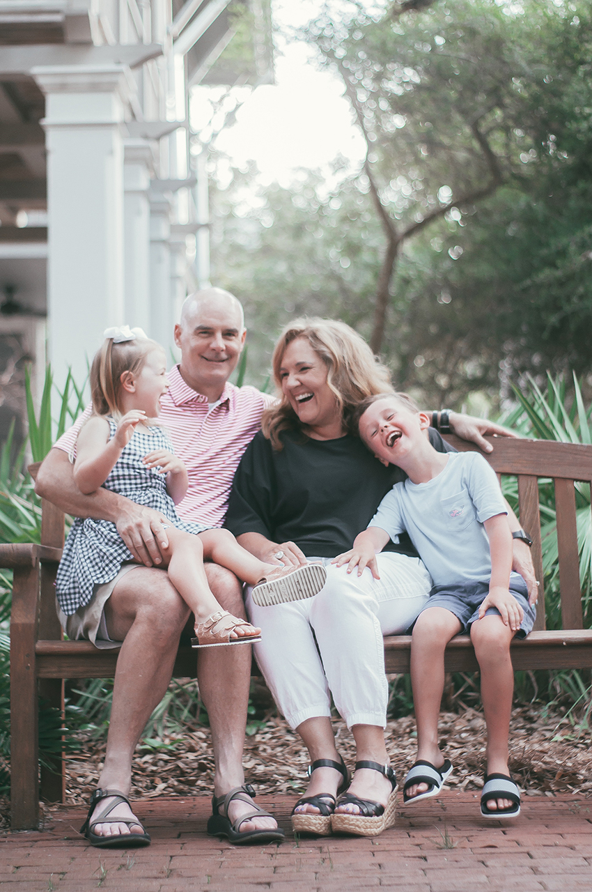 Nanette Johnson with her kids and husband sitting on a bench.