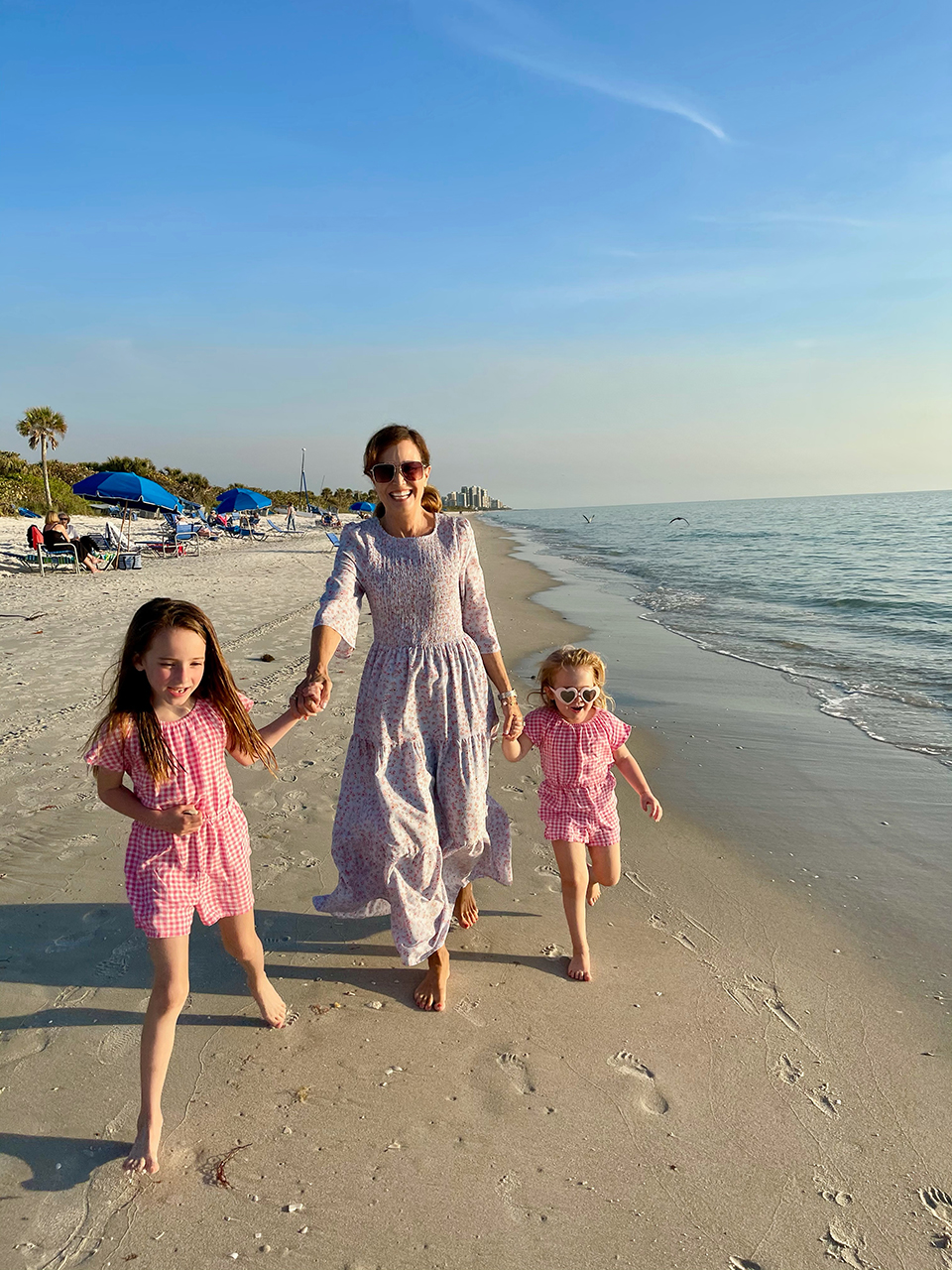 Nancy Weiss walking on the beach with her daughters