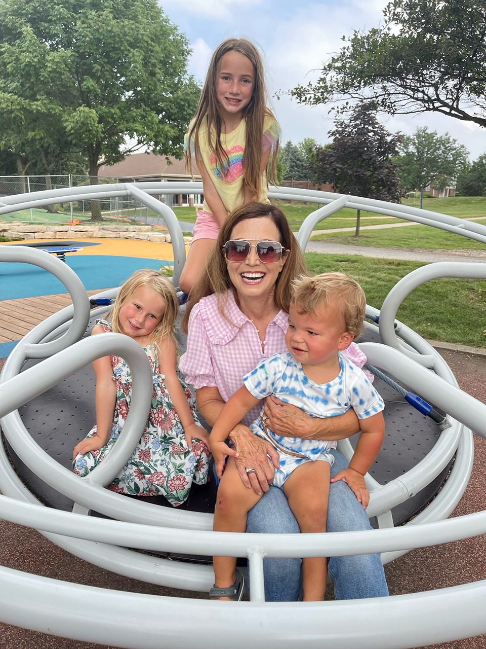 Nancy Weiss with her two daughters on a playground.