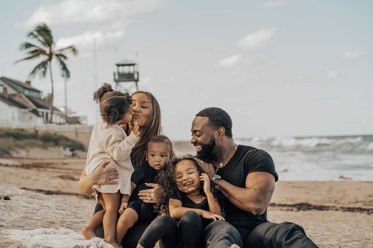 Dana Harvey's family poses for family photo on a beach
