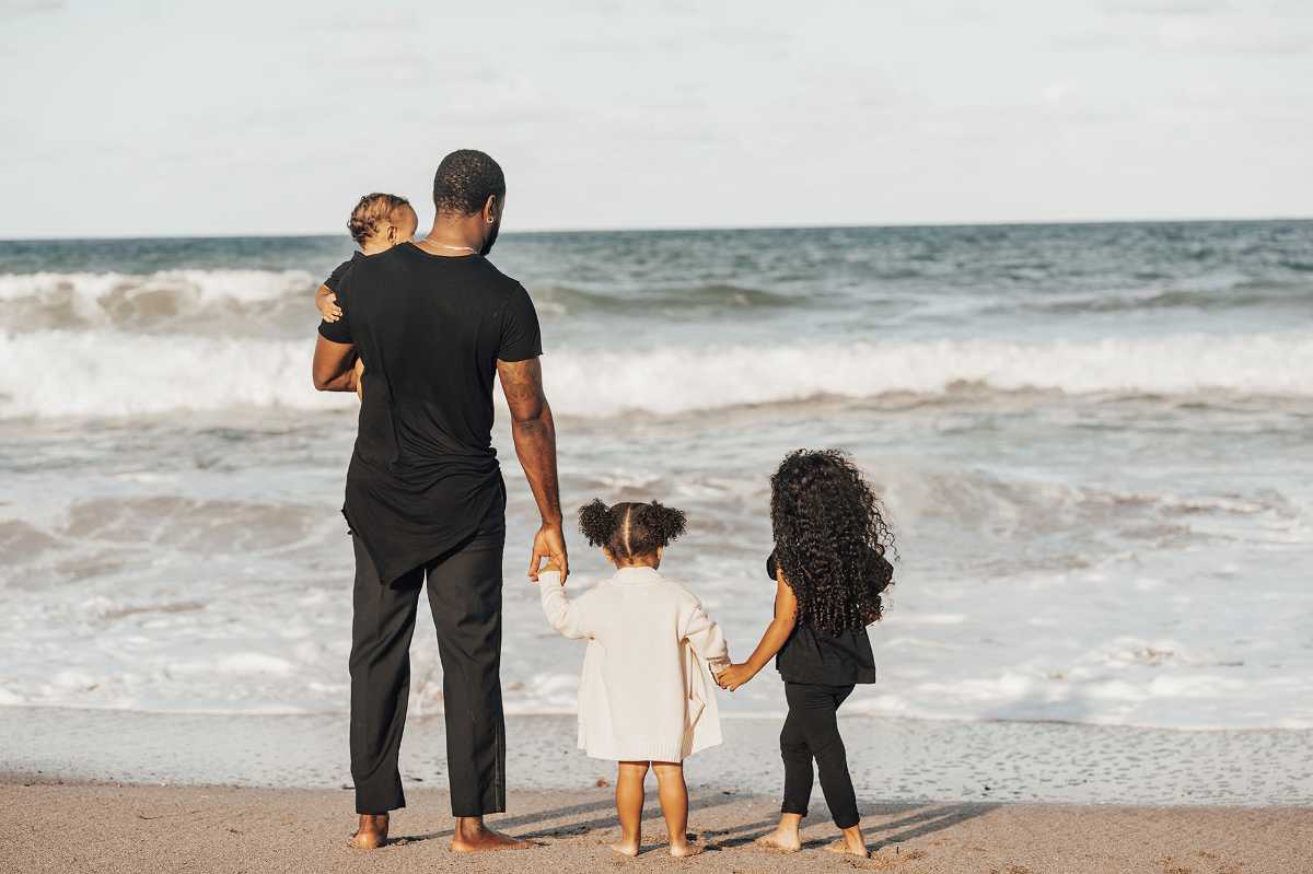 Dana Harvey's husband and three young children watch the waves at the beach